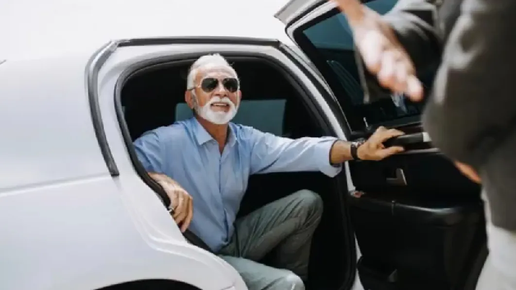 Chauffeur in white gloves holding the door as a passenger steps out of a black SUV