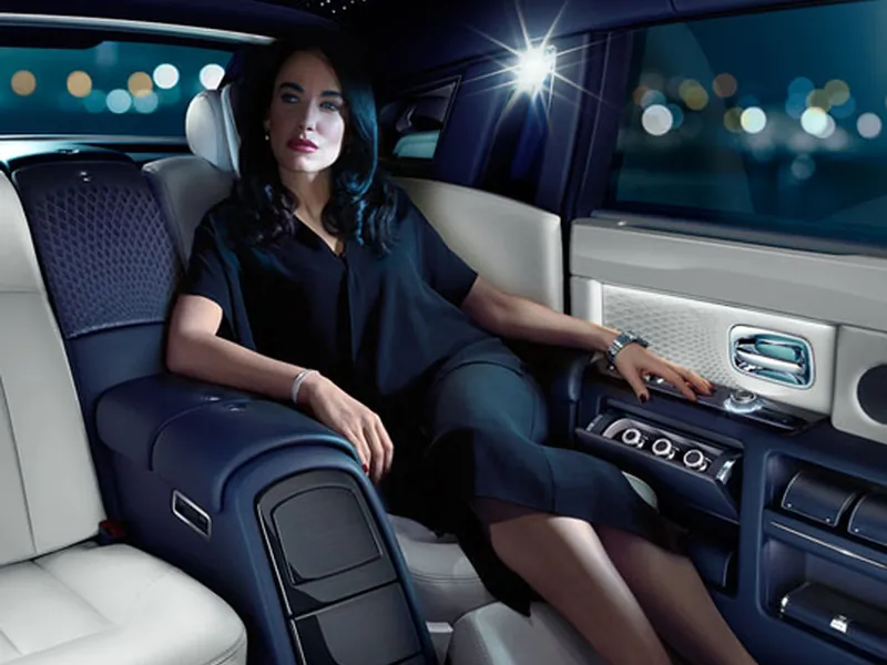 A passenger relaxing in a limousine's rear cabin at night